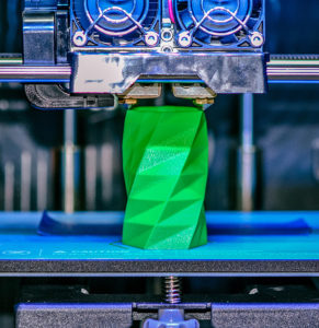 3D printer works and creates an object from the hot molten plastic
